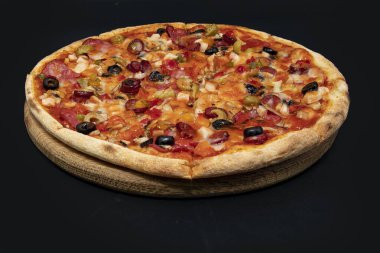 Tahta tahtada servis edilen peynirli, zeytinli, mantarlı, domatesli ve sebzeli taze sıcak pizza menü, kafe, paket servis ve reklam için yakın plan gıda konsepti.