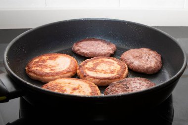 Pişirme sırasında tavayı altın kahverengi köftelerle kapayın. Ev yapımı yemek, fast food hazırlama ve aşçılık süreci konsepti..