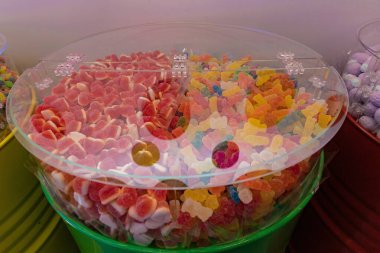 Şeffaf konteynırda renkli ayıcıkları ve kalp şekerlerini kapatın. Şeker dükkanı, parti, çocuk kutlaması, tatil ya da yaratıcı yemek tasarımı için tatlı tatlı bir tatlı..