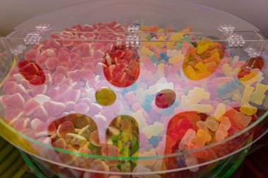 Şeffaf konteynırda renkli ayıcıkları ve kalp şekerlerini kapatın. Şeker dükkanı, parti, çocuk kutlaması, tatil ya da yaratıcı yemek tasarımı için tatlı tatlı bir tatlı..