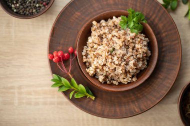 Maydanoz ve biberli kil kasede servis edilen pişmiş karabuğday lapası, geleneksel sağlıklı yiyecek ve vejetaryen diyet konsepti..
