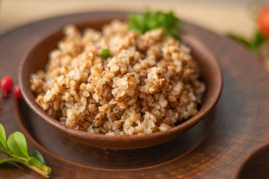 Maydanoz ve baharatlı kil kasede pişmiş karabuğday lapası. Geleneksel sağlıklı yiyecek ve vejetaryen diyet konsepti.