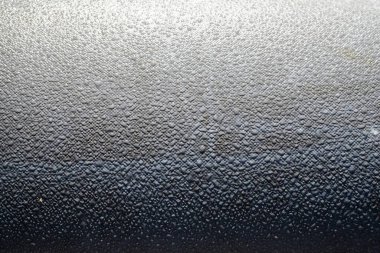 Close up of gray textured surface with water drops and glossy details. Perfect for abstract backgrounds, modern design, and decorative concepts.