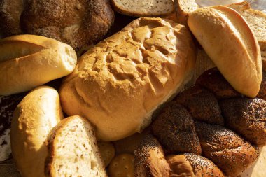 Türlü taze ekmek somunlarını ve kırsal dokulu dilimleri kapatın. Ev yapımı fırın, geleneksel yemekler, zanaatkar pişirme ve organik ekmek konsepti..