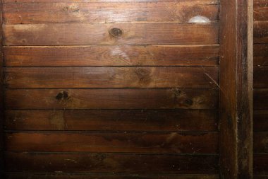 Görünür düğümleri, çizikleri ve sıcak kahverengi tonları olan kırsal ahşap kalasları kapatın. Tasarım, dekorasyon, inşaat ve eko kavramları için doğal ahşap dokusu.