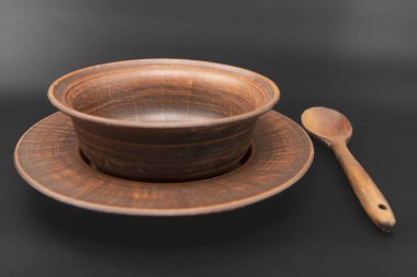 Kırsal ahşap kase ve kaşık siyah arka plana yerleştirilmiş. Geleneksel mutfak gereçleri, çevre dostu doğal gereçler, köy tarzı aşçılık konsepti..