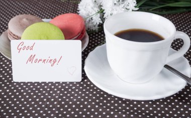 Kahve, kek masada ve arka planda çiçek fincan