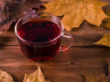 Fincan çay ve akçaağaç arka planda ahşap bir masaya bırakır.