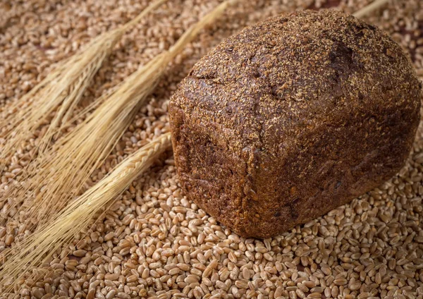 Bread, ears of wheat against a background of scattered wheat. The concept of a healthy diet