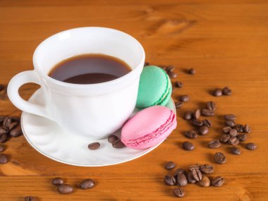 Fincan kahve ve Fransızca macaroons ve beyaz buket çiçek 
