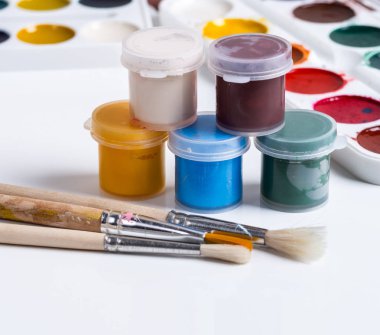 Guaj, fırçalar ve beyaz zemin üzerine suluboya