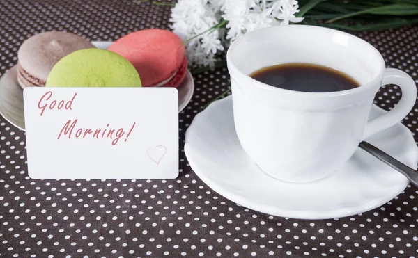 Kahve, kek masada ve arka plan üzerinde beyaz çiçekler ile Kupası