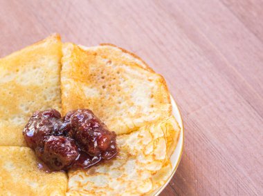 Bir plaka üzerinde reçelli krep. Yakın çekim. Ahşap arka plan