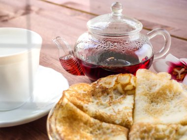 Tabak krep, ahşap bir tabloda çay çaydanlık