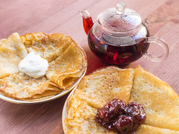 Krep plakaları. Reçel ve krema ile. Demlik çay ile. Ahşap bir arka plan üzerinde