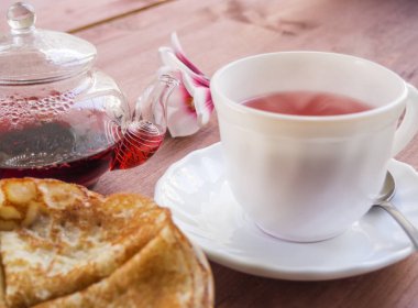 Ev yapımı kahvaltı krep. Tabak krep, ahşap bir tabloda çay çaydanlık