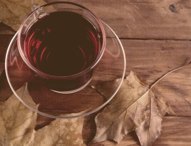 Çay, akçaağaç yaprakları ahşap arka plan üzerinde