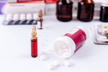 Ampul enjeksiyon, tablet ve beyaz bir tablo üzerinde tıbbi şişeler ambalaj için