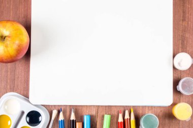 Beyaz çarşaf kağıt kalem ve ahşap arka plan üzerinde renkli boya