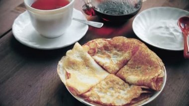 Krep ve masanın üzerine ekşi krema ile çay