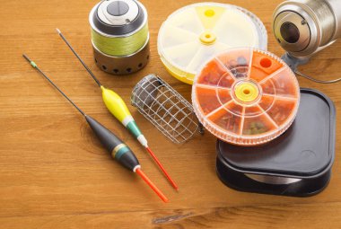 Balık tutma araçları, yüzen, kanca ve ahşap arka plan üzerinde siyah bir metal besleyici