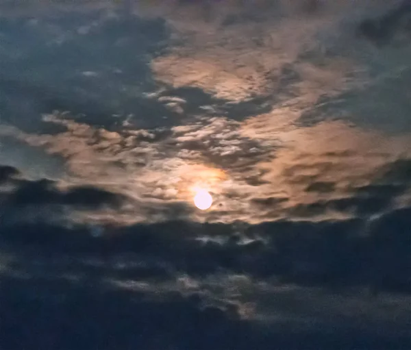 The moon looks through an opening in the clouds — Stock Photo, Image