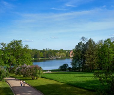 Nehir bankalara yeşil ağaçlar ve mavi bulutlu gökyüzü ile göster