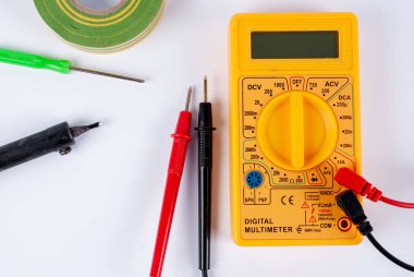 Beyaz zemin üzerinde çoklu metre, tornavida ve lehim demiri.