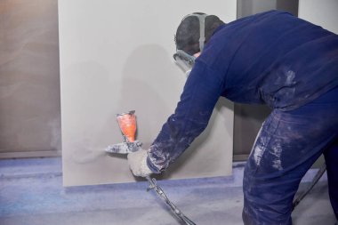 Bir adam toz boya metal ürünleri üretir.