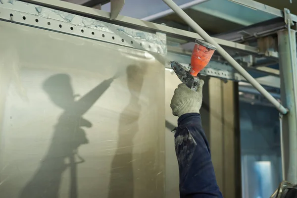 Bir adam toz boya metal ürünleri üretir.