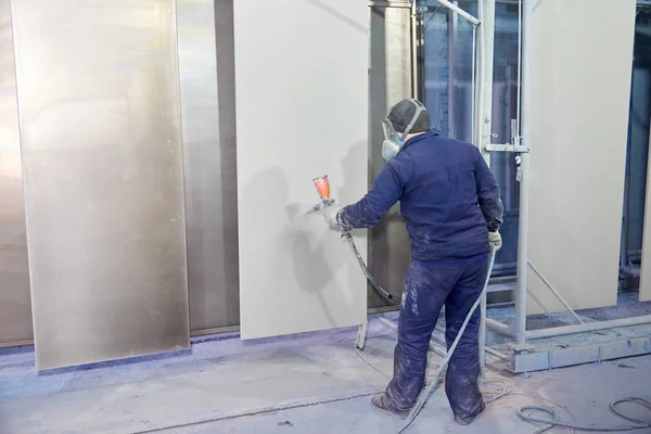 Bir adam toz boya metal ürünleri üretir.