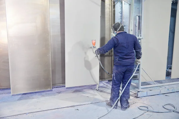 Bir adam toz boya metal ürünleri üretir.