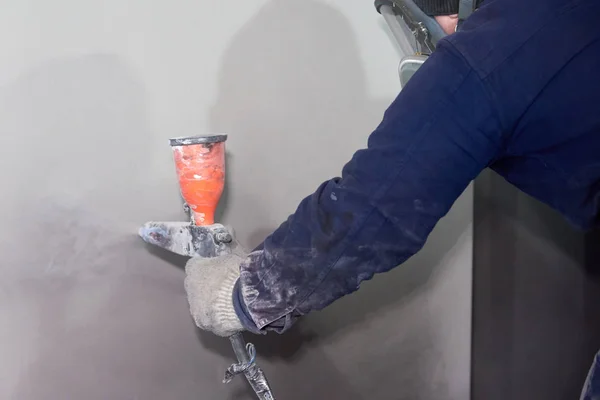 Bir adam toz boya metal ürünleri üretir.