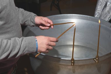 bir adam bir çocuğun vaftiz önce mumlar yanar