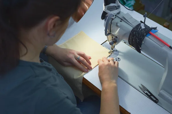 Una mujer cose en una máquina de coser eléctrica . — Foto de Stock