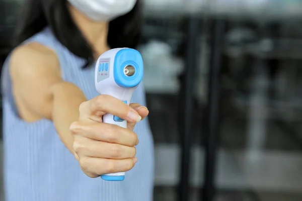 Yüz maskesi takan personel girişte dijital termal tarayıcı kullanmıyor. Covid gribini koruma kavramı. İnsanları alışveriş merkezine, süpermarkete, kantine girmeleri için kontrol et..