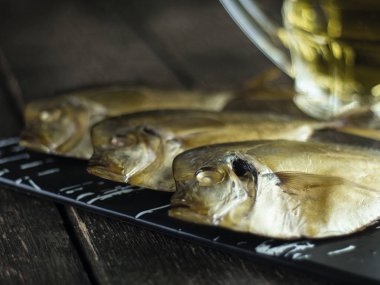 Ahşap arka planda füme balık ve bira. Yan görünüm