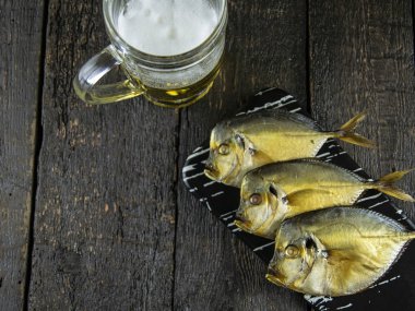 Ahşap arka planda füme balık ve bira.