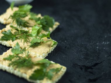 Koyu taş üzerinde gevrek ekmek ve krem peynir ile sağlıklı kahvaltı