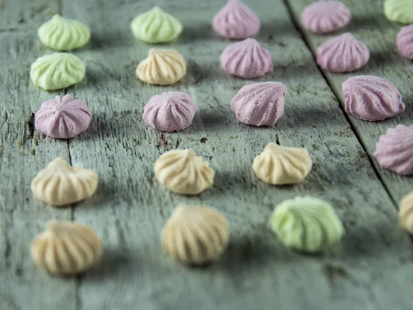 Meringue cakes on wooden background