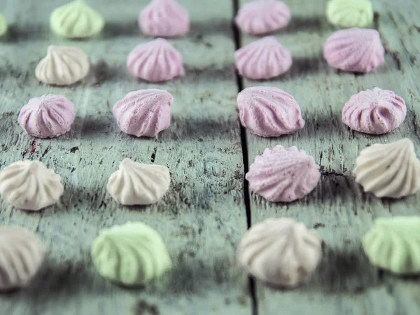 Meringue cakes on wooden background