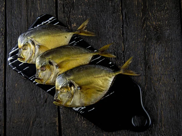 Копченая рыба и пиво на деревянном фоне . — стоковое фото