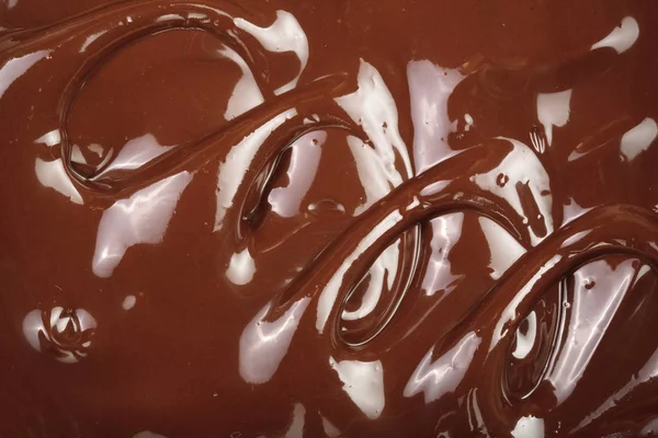 Круговорот расплавленного шоколада как фон крупным планом — стоковое фото