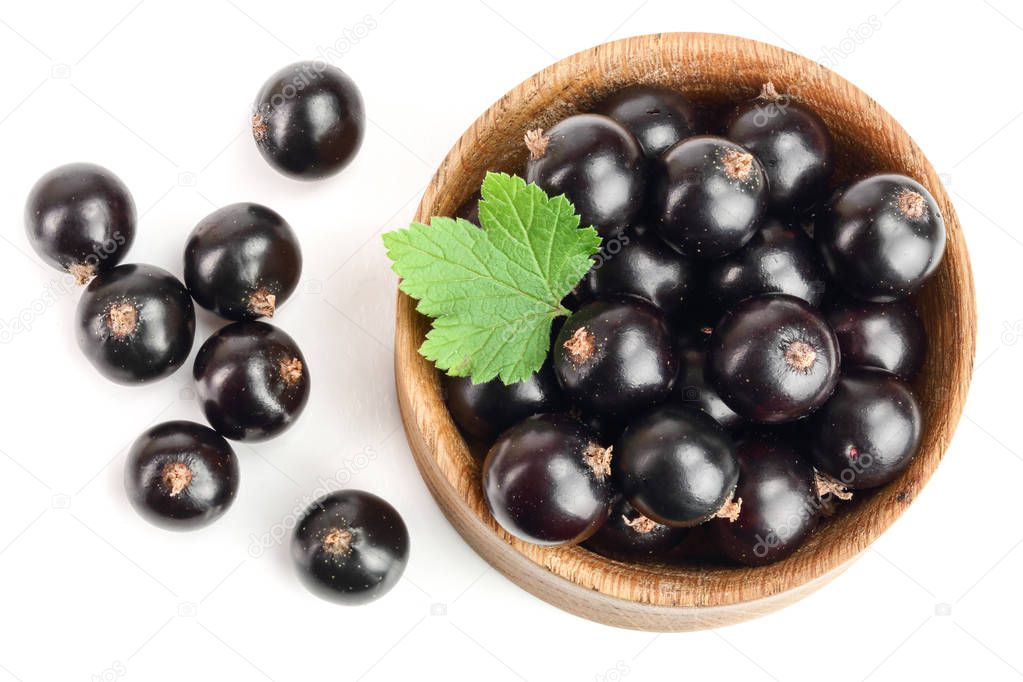 black currant with leaf in wooden bowl isolated on white background. Top view. Flat lay pattern.