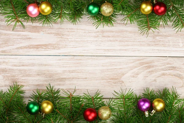 Χριστουγεννιάτικο καρέ από κλαδιά έλατου διακοσμημένη με μπάλες σε ανοιχτόχρωμο φόντο ξύλινη — Φωτογραφία Αρχείου