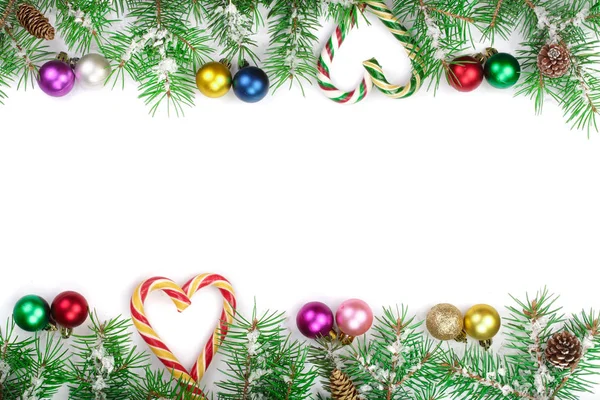 Marco de Navidad de rama de abeto con bastones de caramelo y bolas aisladas sobre fondo blanco con espacio de copia para su texto —  Fotos de Stock