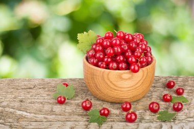 Frenk üzümü çilek bulanık Bahçe arka plan ile ahşap masa üzerinde ahşap kase