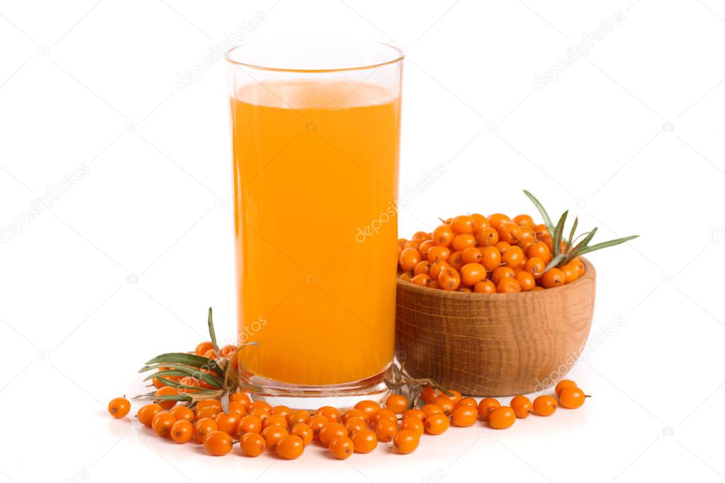 Sea buckthorn juice in a glass and wooden bowl with berries isolated on white background