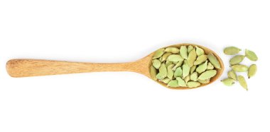 Tahta kaşık beyaz arka plan üzerinde izole içinde yeşil kakule tohumu. Üstten Görünüm. Yat.