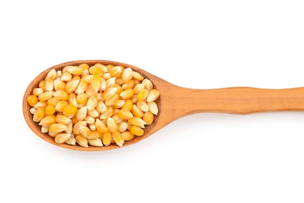 Les graines de maïs dans une cuillère en bois isolé sur fond blanc. Vue de dessus. Pose plate — Photo